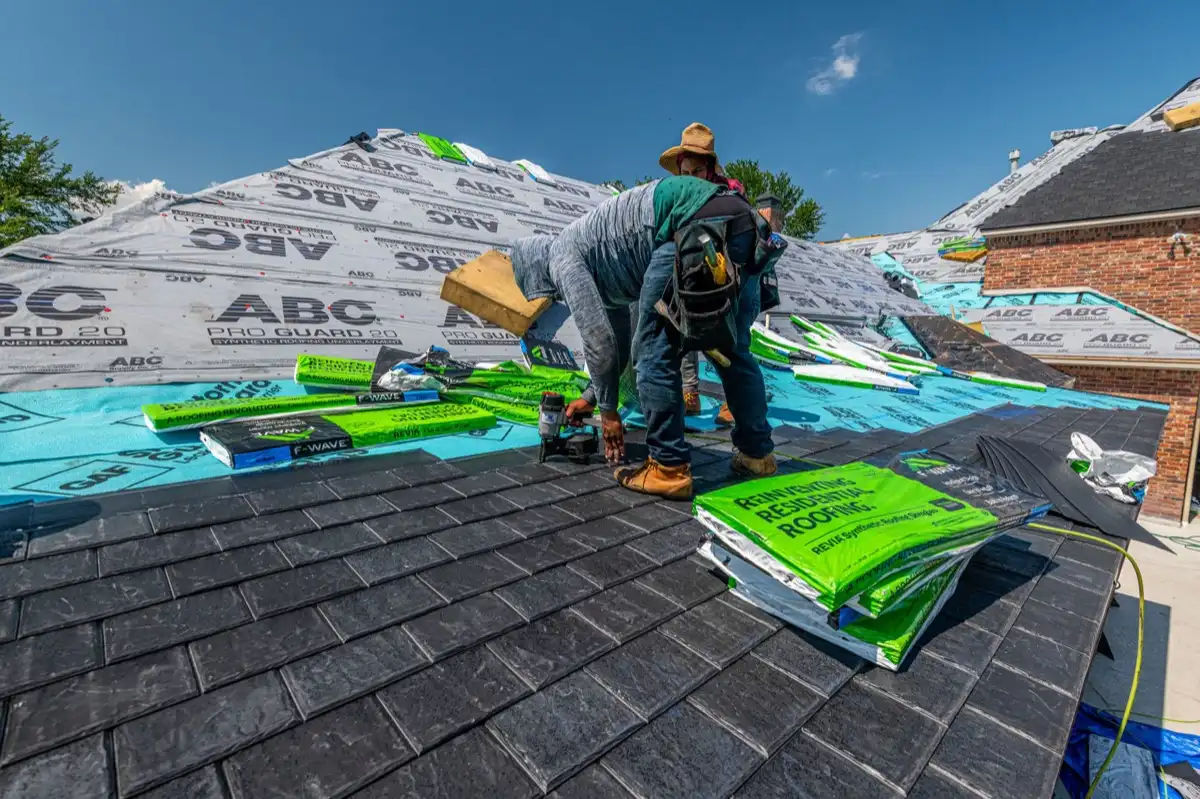 Roofing crew installing underlayment on a stripped deck in Battle Creek, MI